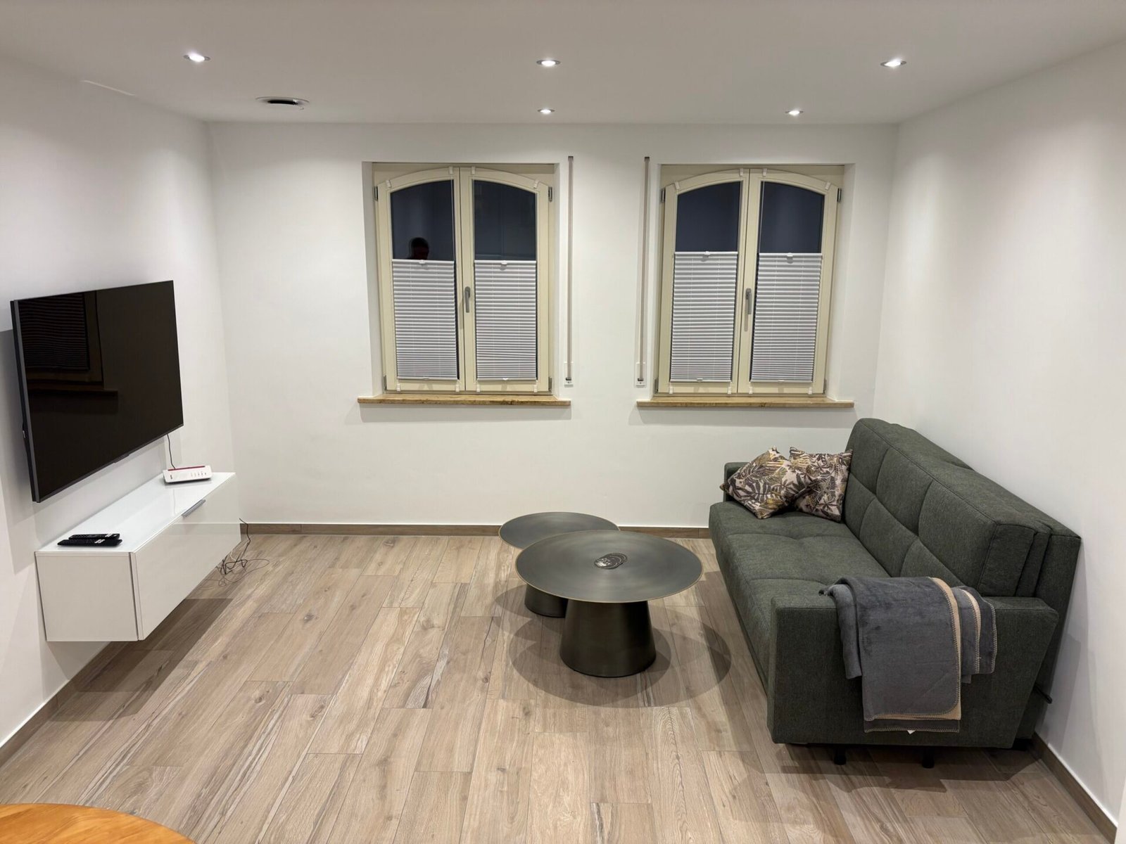 Helles Wohnzimmer der Ferienwohnung Mano mit Schlafsofa, Couchtisch und Smart-TV