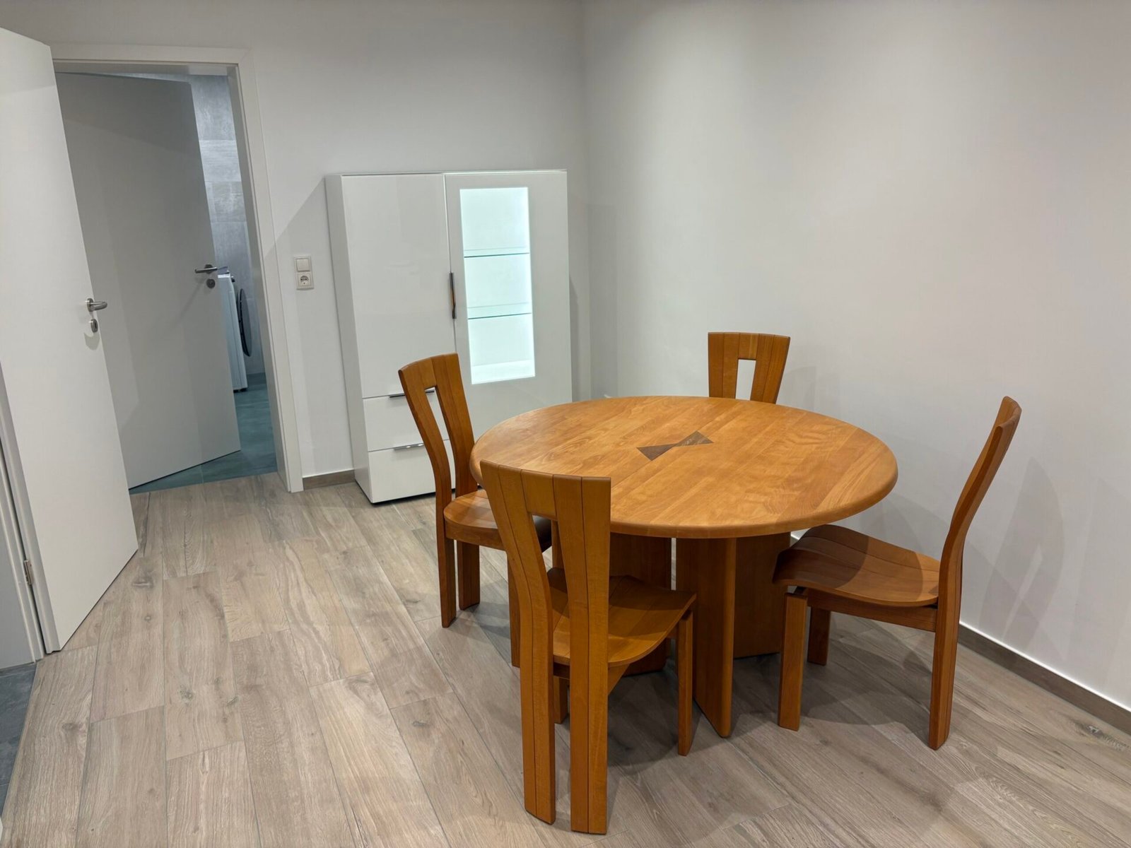 Runder Esstisch aus Holz mit vier Stühlen im Essbereich der Ferienwohnung